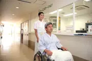 看護師が患者さんの車いすを押す